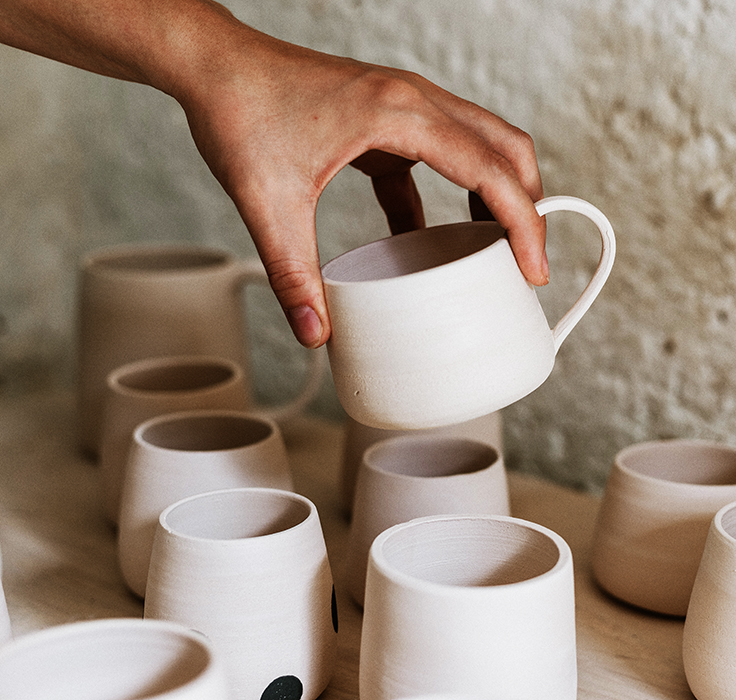 Woman examing her clay pots